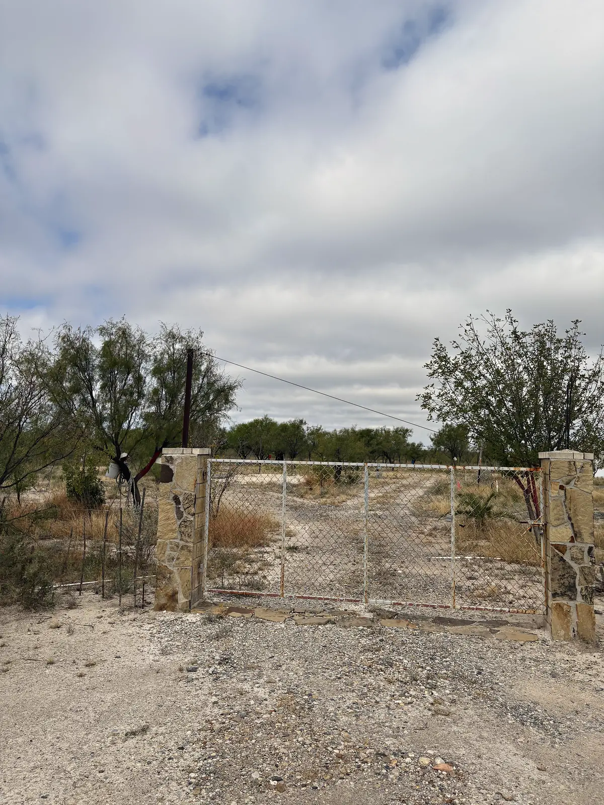 Entrada del Terreno Nogalitos: portón de malla con pilares de piedra